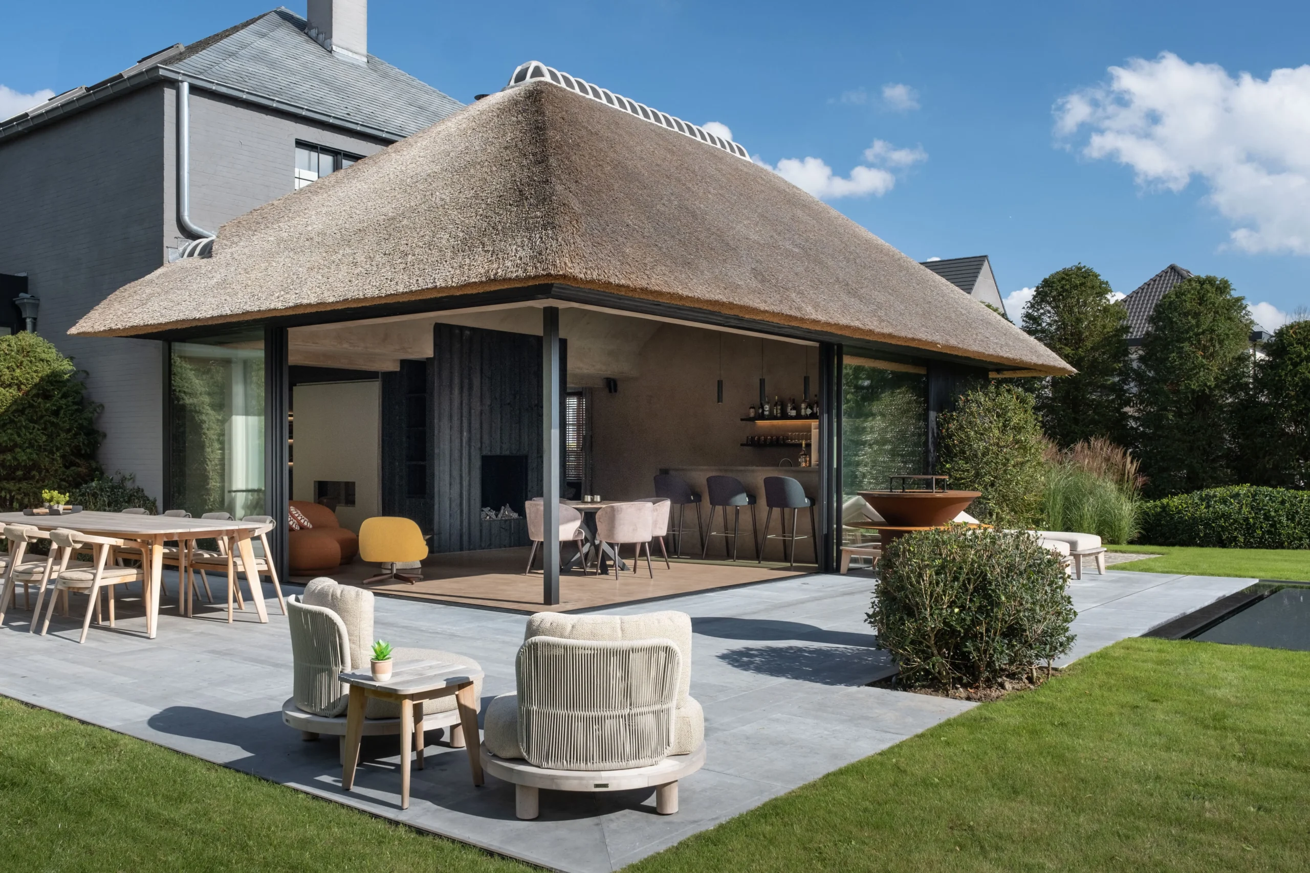modern bijgebouw met rieten dak en terras