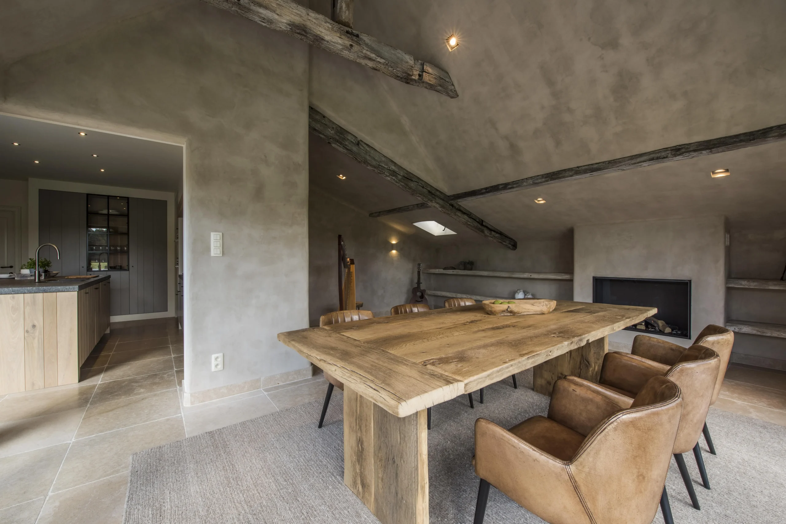 Interieur met lange eettafel en betonnen plafond.