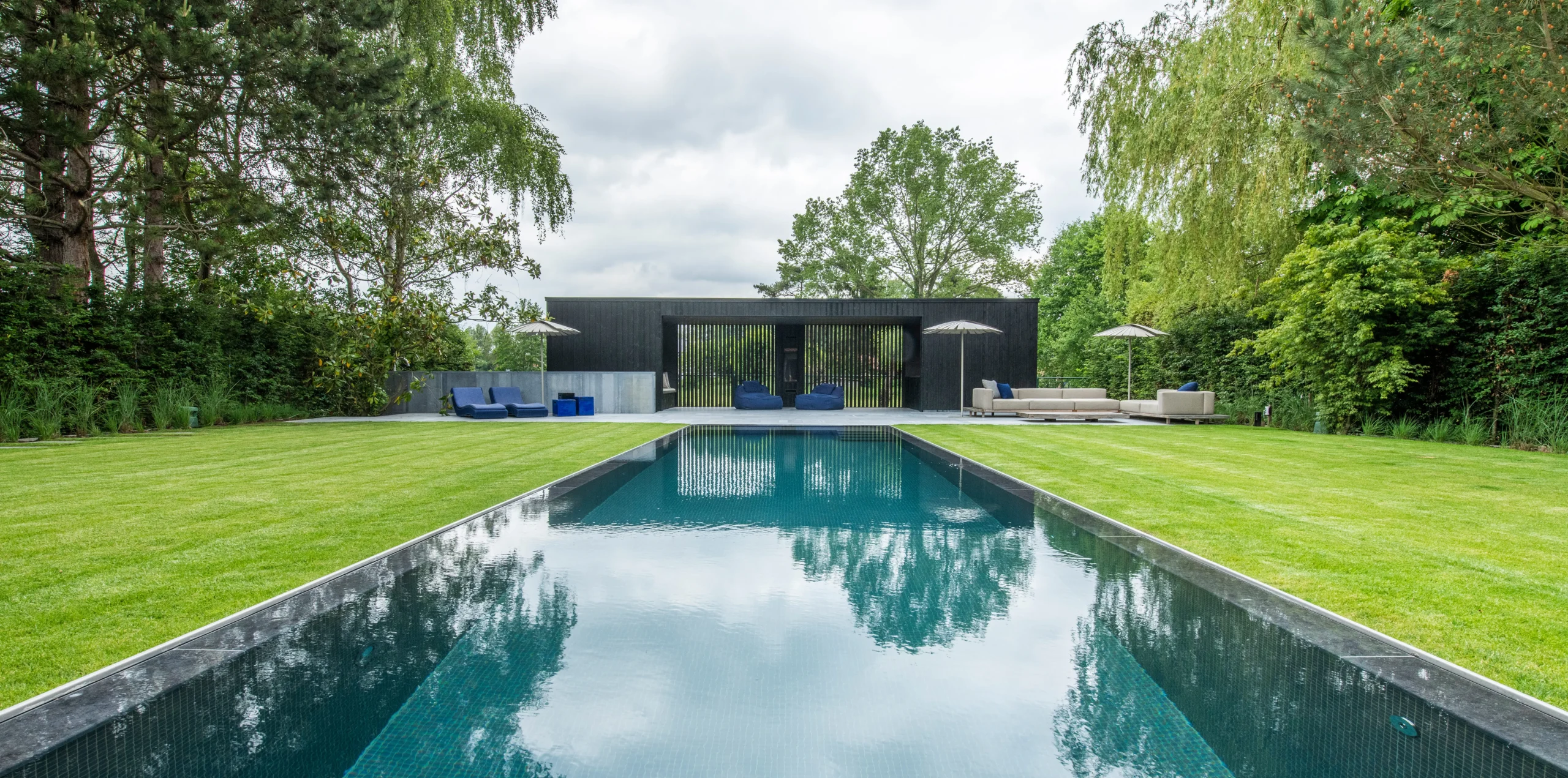 Moderne tuin met groot zwembad en symmetrische lijnen.