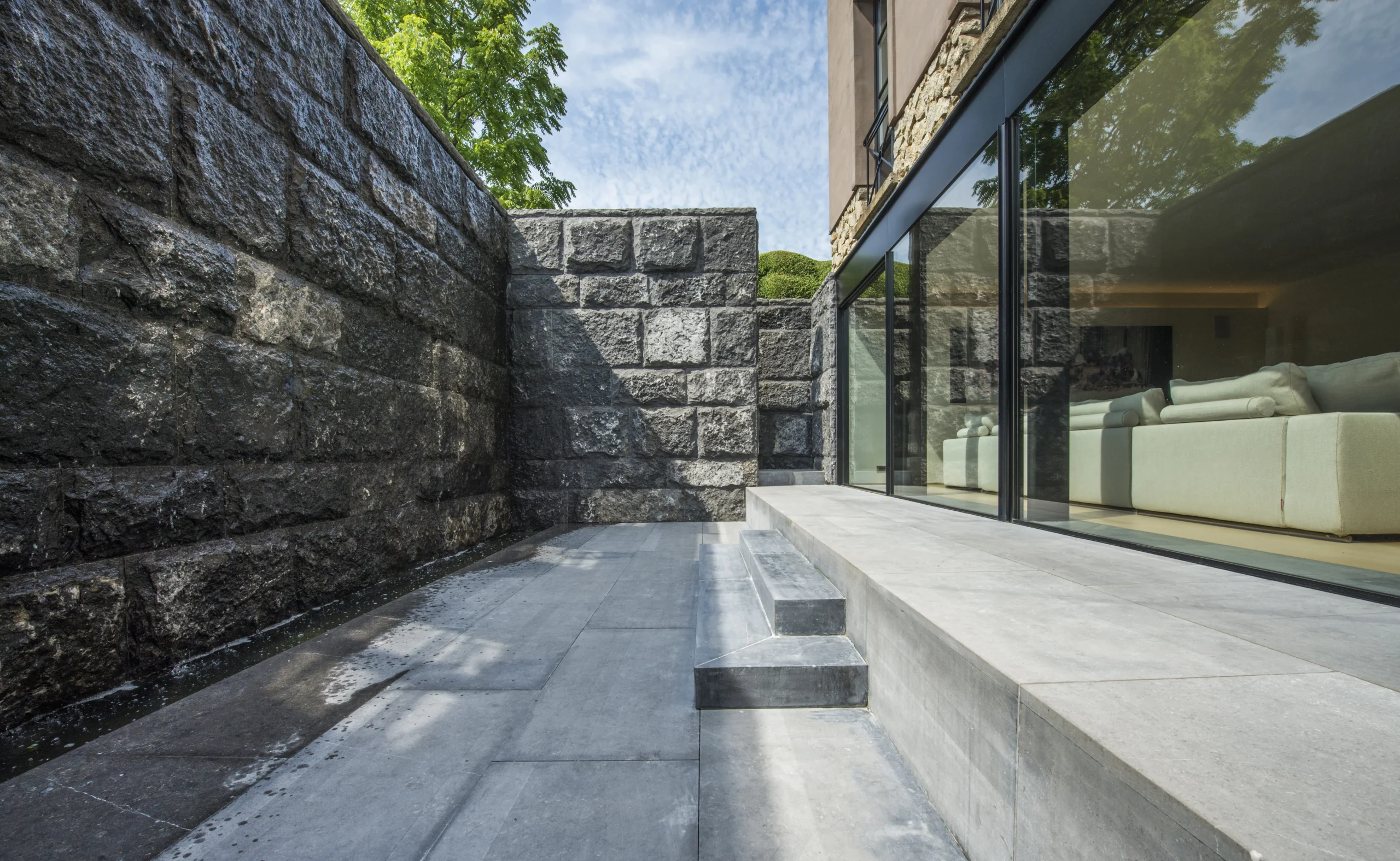 Moderne patio met strakke lijnen en natuurstenen muren.