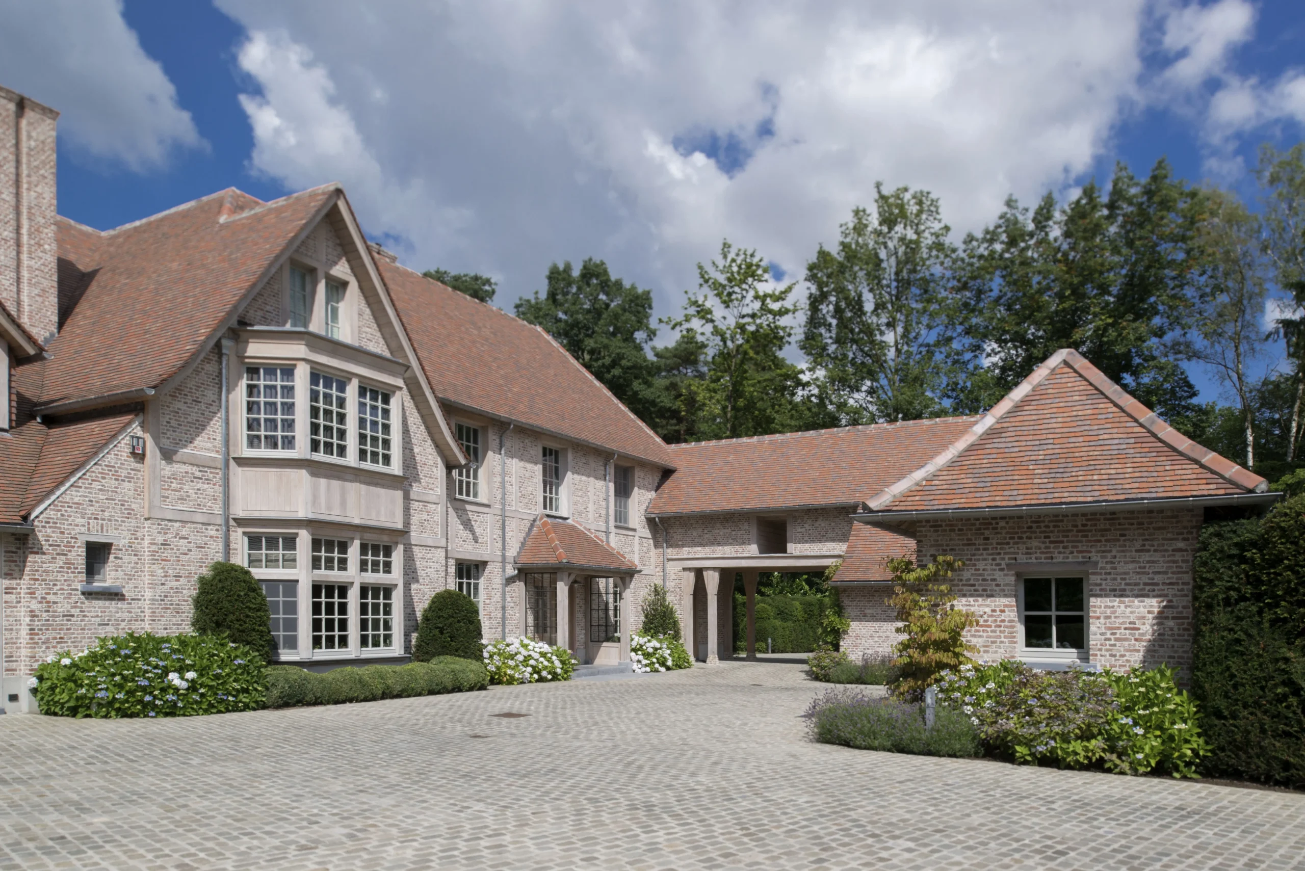 Landelijke villa met oprit en symmetrische voorgevel.