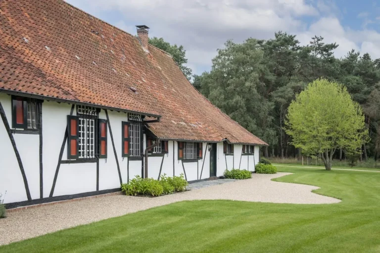 Klassieke hoeve met symmetrische voorgevel en sierlijke tuin.